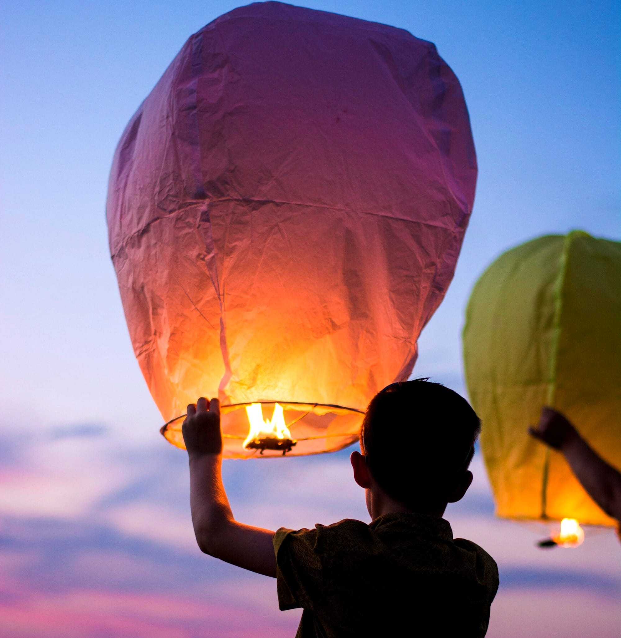 person holding yellow flammable balloon